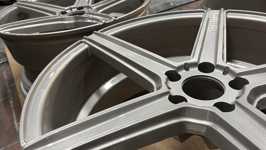 Mehrere silber veredelte Felgen als Stapel in der Werkstatt